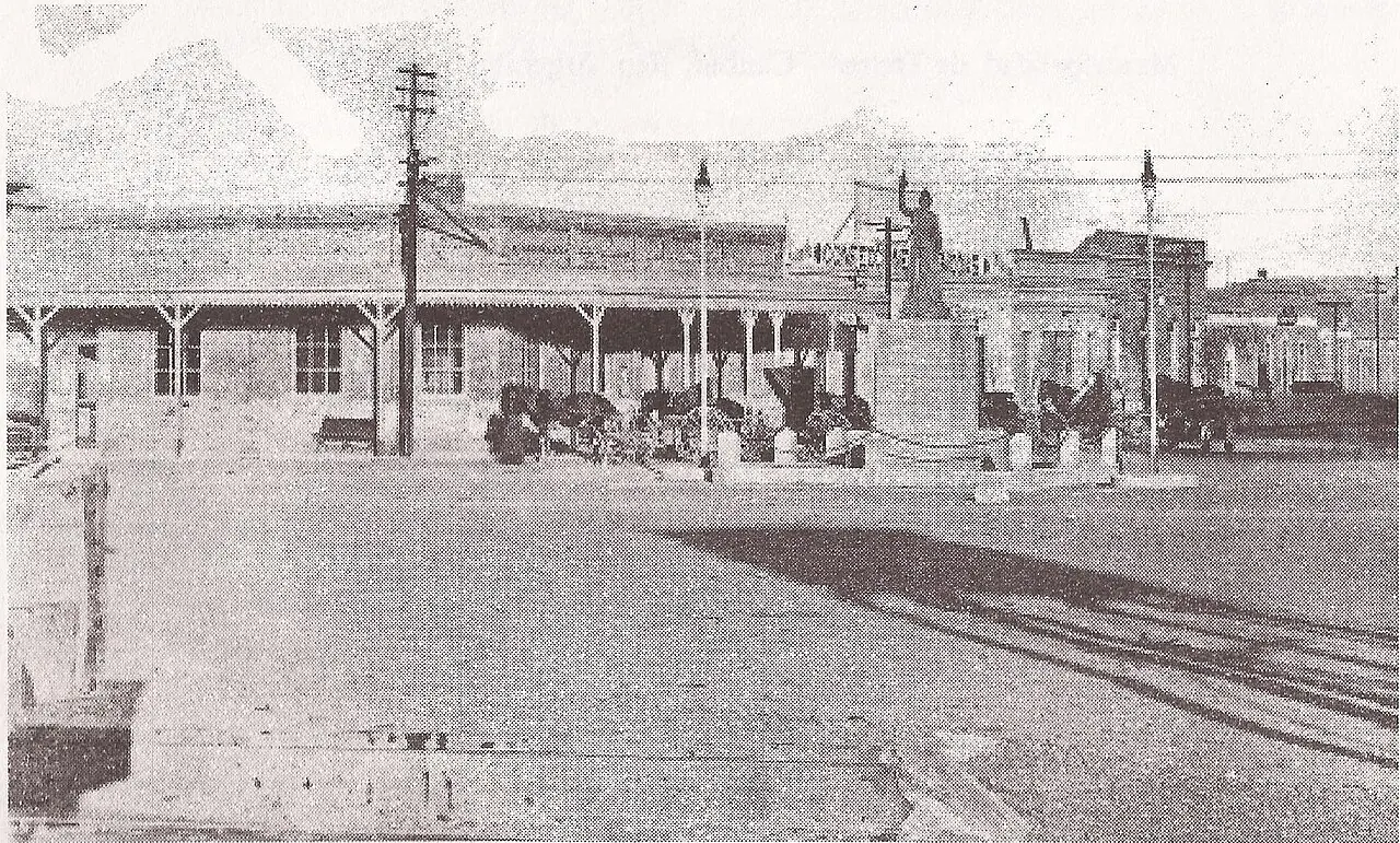 Early twentieth-century photograph of a long single-storey store with a veranda